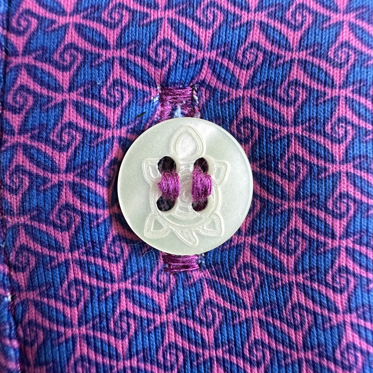 Magenta 11-Stitch on a pink and blue pattern