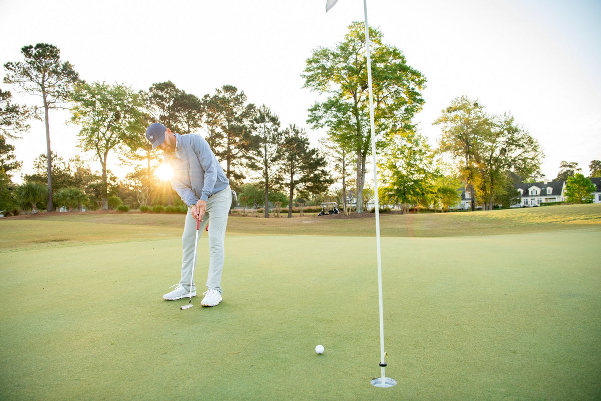 Golfer putting in warm evening light